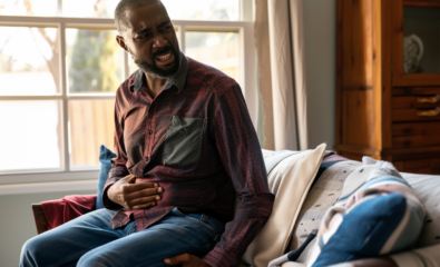 Man sitting holding stomach because of stomach pain