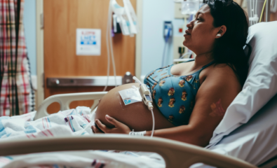 Pregnant woman in hospital with monitors attached to her.