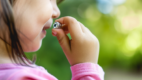 Child holding a battery near mouth