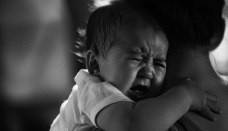 Infant with apnea crying on mothers shoulder