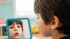Child practicing the /p/ sound with a mirror
