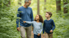 A parent and two children walking through a forest trail in long sleeves to avoid tick bites