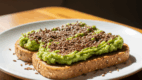 Healthy whole grain toast topped with mashed avocado and flax seeds