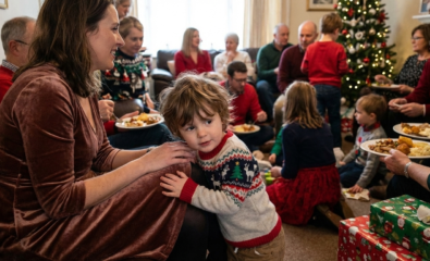 Young child standing close to a parent during a busy holiday family gathering.