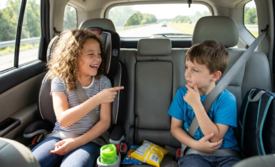 Siblings sitting in the back seat playing a verbal road trip game together