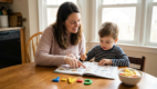 Parent helping preschool child blend letter sounds into a simple word.
