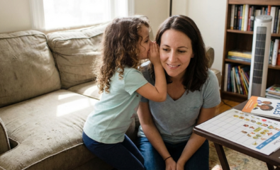 Child whispering to parent as a small step forward in selective mutism support.